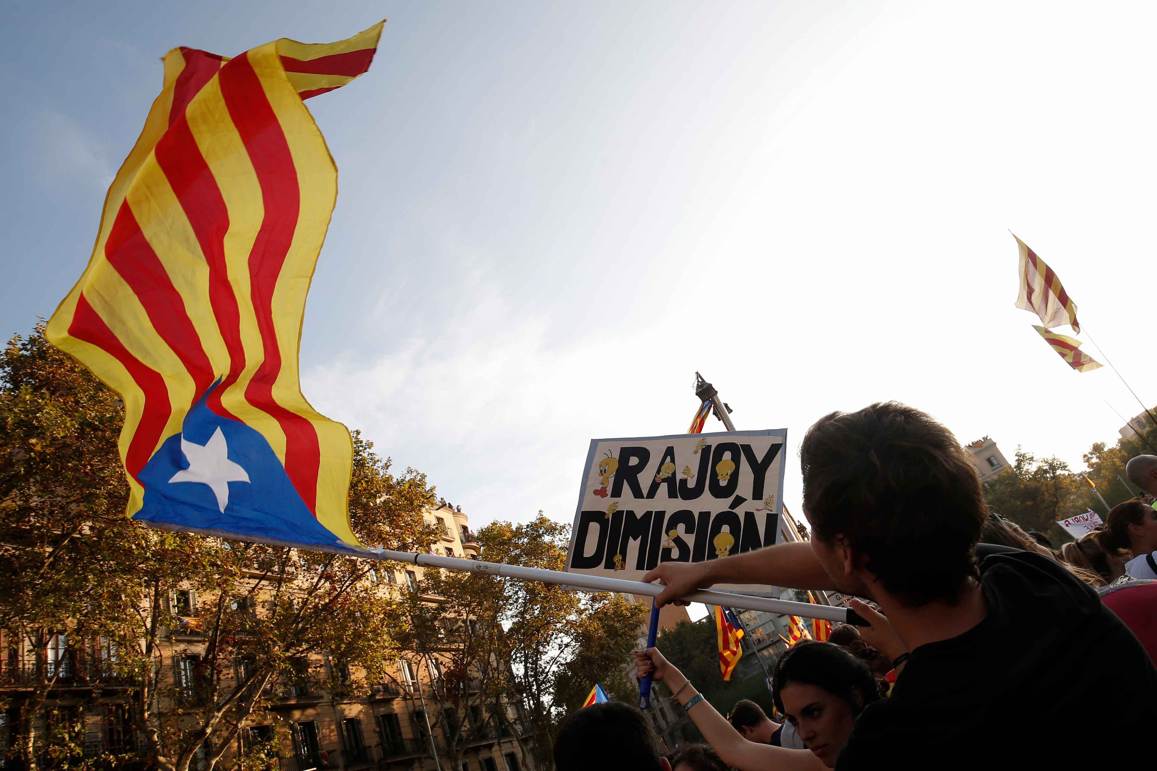 A man holds a Catalan pro-independence 'Estelada' flag in Barcelona during a general strike in Catalonia called by Catalan unions on October 3, 2017. Large numbers of Catalans observe a general strike today to condemn police violence at a banned weekend referendum on independence, as Madrid comes under growing international pressure to resolve its worst political crisis in decades. / AFP PHOTO / PAU BARRENA
