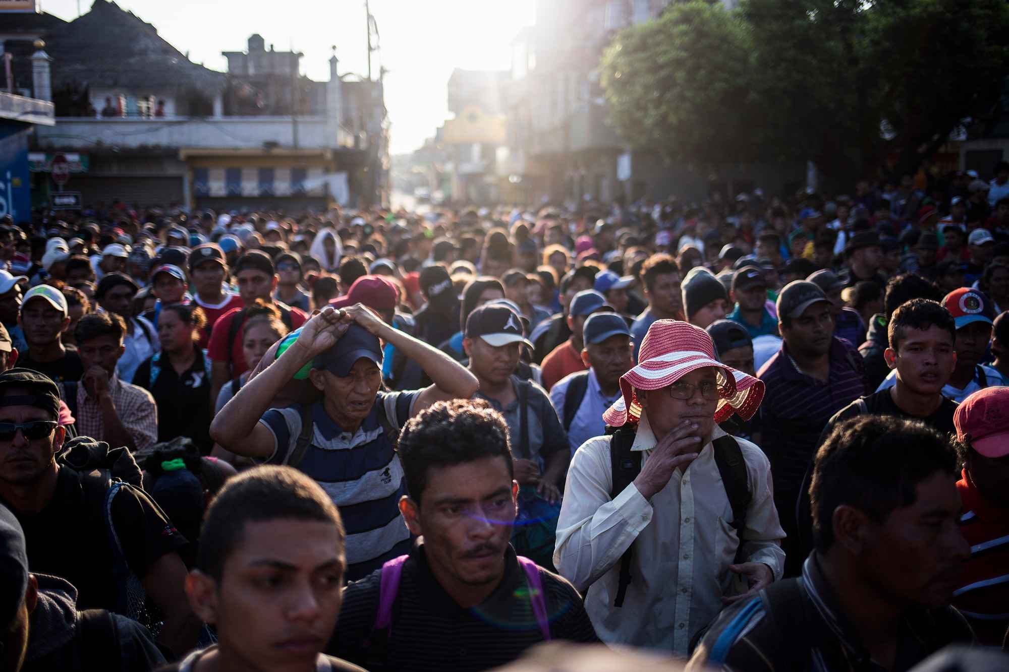 Una caravana de migrantes espera frente al portón de la aduana guatemalteca, en el paso de la frontera Tecún Umán. Más de 2 mil personas, procedentes de los países del Triángulo Norte de Centroamérica, llegaron a este lugar para cruzar a México y caminar hacia Estados Unidos. Foto: Víctor Peña.