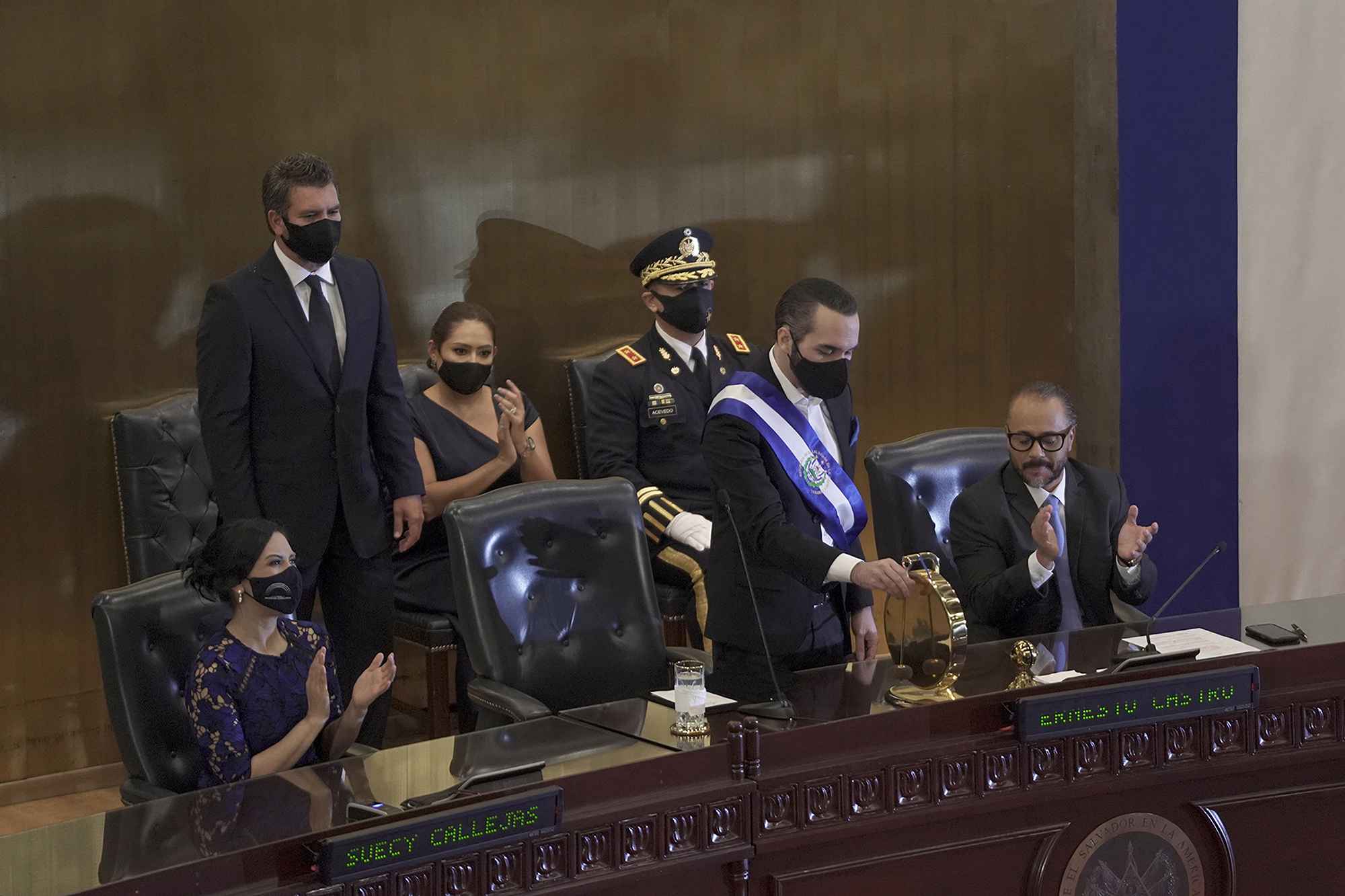 El 1 de junio de 2021, el presidente Bukele cumplió dos años de Gobierno. En una sesión solemne en la Asamblea, gobernada por diputados de su partido, Bukele inauguró la actividad haciendo sonar el gong, una potestad exclusiva del presidente del Órgano Legislativo. A su izquierda, su amigo y exasistente, Ernesto Castro, actual presidente de la Asamblea. Foto de El Faro: Víctor Peña.