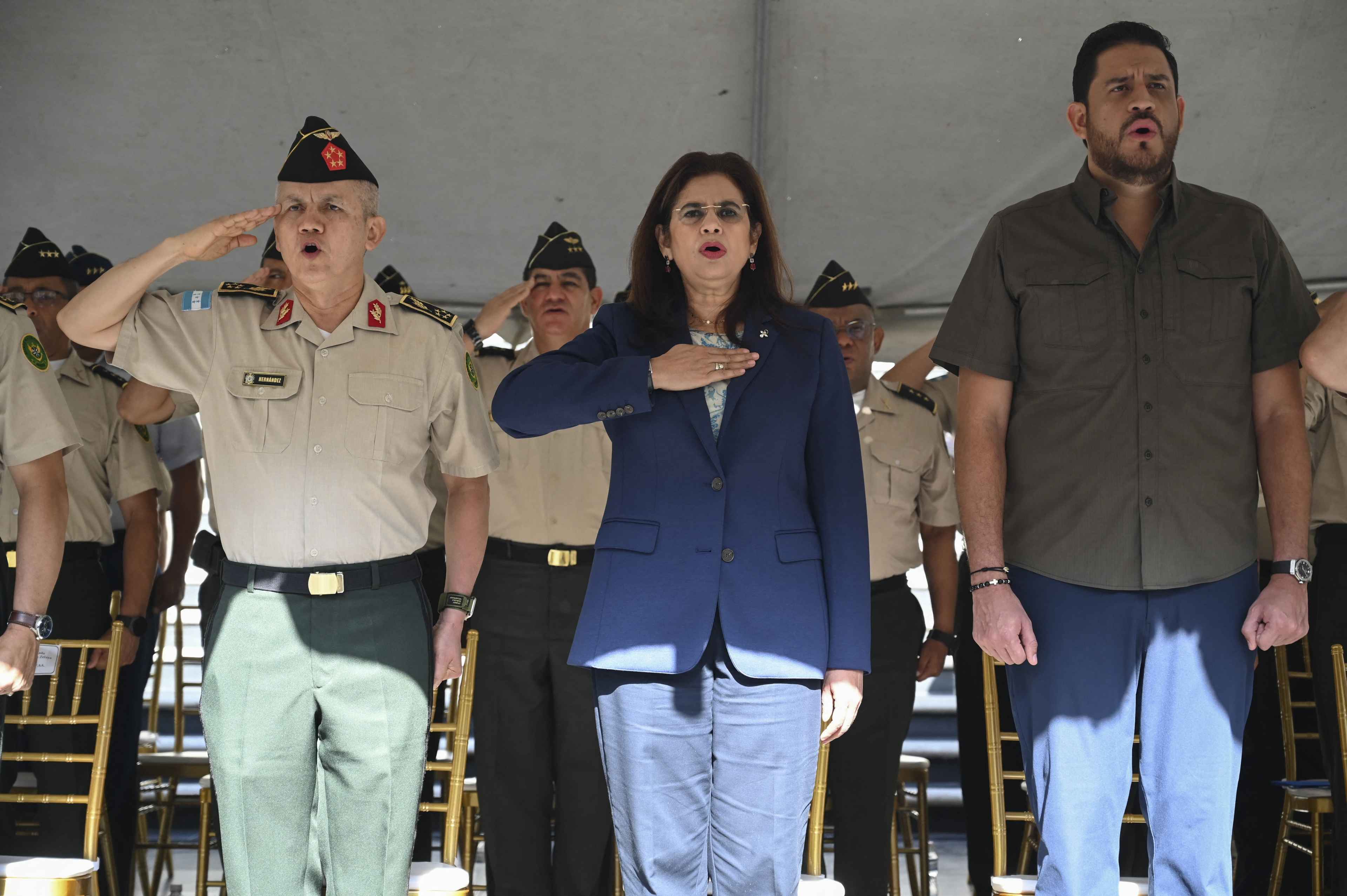 From left to right: Honduras' Armed Forces Joint Chiefs of Staff, Major General Roosevelt Leonel Hernández; new Defense Minister Rixi Moncada, a pre-candidate for the presidency with the ruling party Libre; and outgoing Defense Minister Manuel Zelaya sign the national anthem during Moncada's inauguration ceremony at the facilities of the Joint Chiefs of Staff in Tegucigalpa on September 2, 2024. Photo Orlando Sierra/AFP