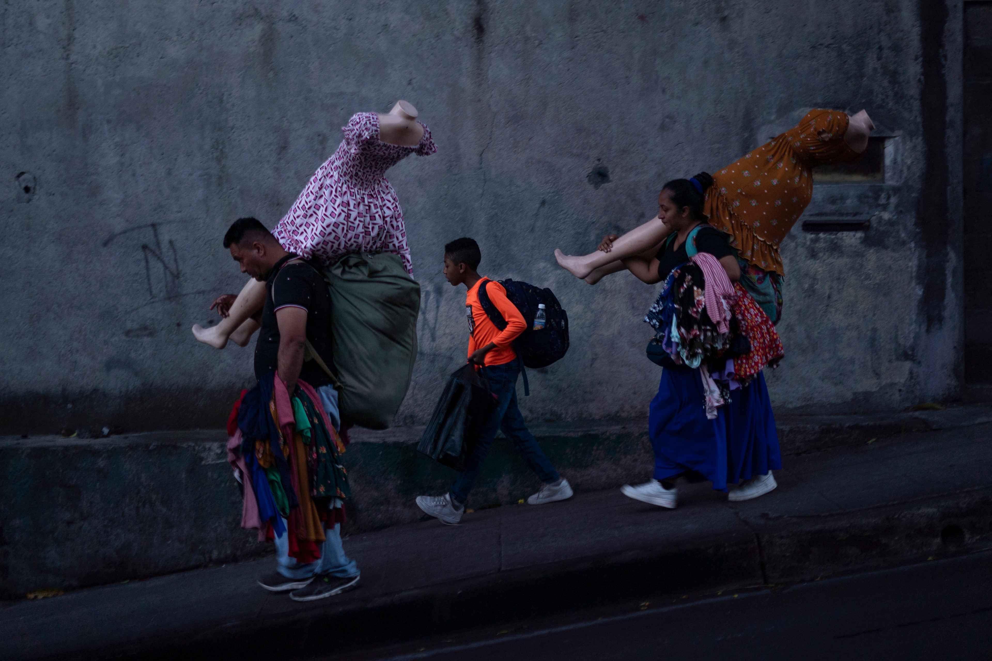 Una familia de vendedores camina rumbo a la zona de la plaza Zurita, sobre la octava calle oriente, en el Centro de San Salvador. En esa misma zona convergen otros vendedores que también huyen de los agentes del Cuerpo de Agentes Metropolitanos (CAM), que mantienen operativos permanentes para desplazar y decomisar los productos a los comerciantes informales que se acercan a las cuadras revitalizadas del Centro Histórico. Entre las múltiples conversaciones resaltan algunas frases: “A esos del gobierno el dinero los ha vuelto locos”. “Todos estos van a tener mal fin”. “Ellos no tienen hambre, ellos tienen todo”. “O se cansan ellos o nos cansamos nosotros”. Foto de El Faro: Víctor Peña.   