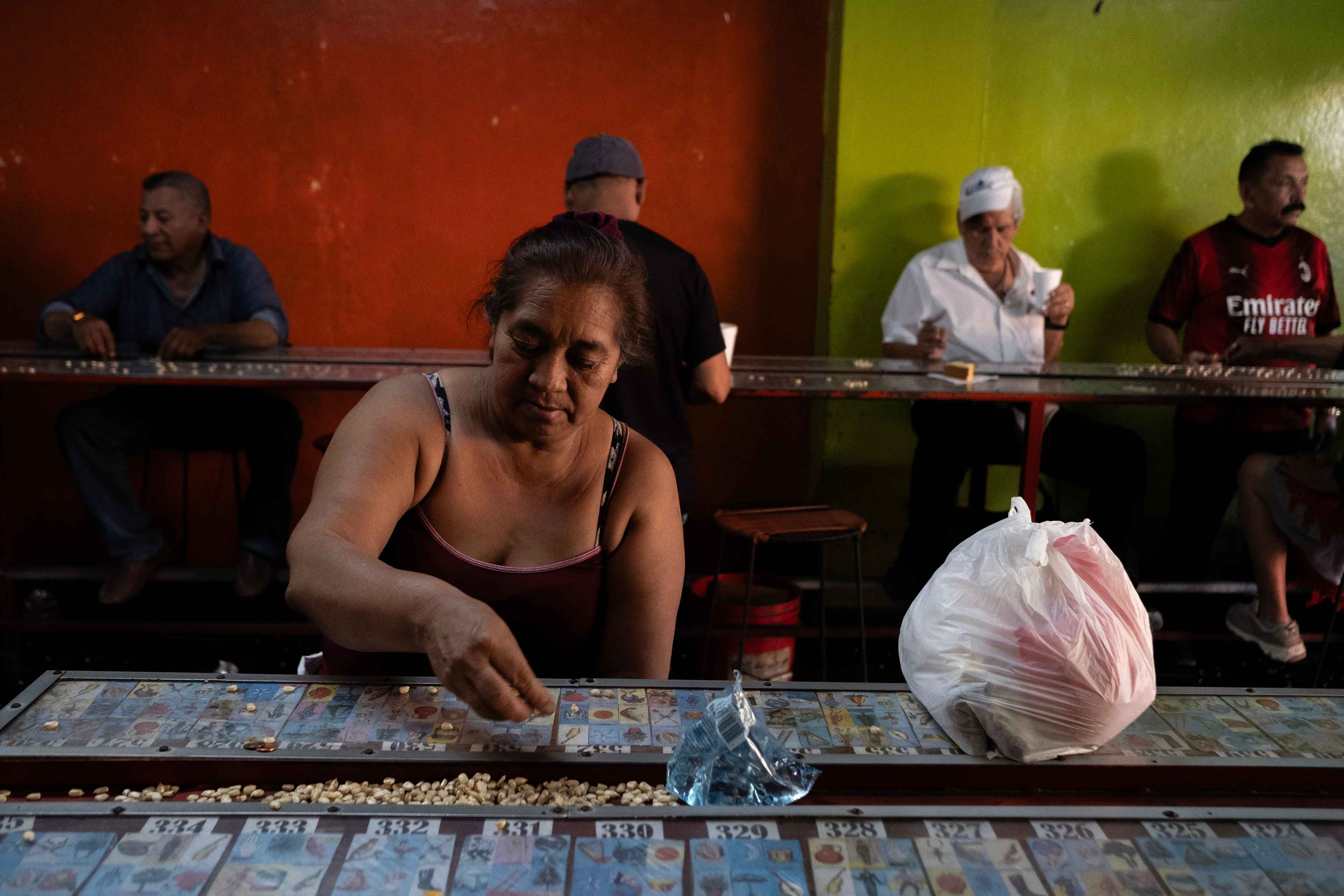 Mari Santos, de 55 años, es una vendedora ambulante de verduras del Centro Histórico. Como gran parte de los vendedores, Mari es habitante de las decenas de mesones que rodean las principales cuadras remozadas. Para ganarse la vida corretea todos los días tratando de esconderse de los agentes del CAM que decomisan la venta de aquellos que se atreven  a acercarse a las principales plazas del Centro, "Ahorita aquí estoy matando el tiempo en la lotería para subir más noche y correr de los del CAM. Yo prefiero no vender a que el producto se vaya a pudrir a las bodegas de la alcaldía y por eso espero la noche porque es más fácil huir", dijo. Foto de El Faro: Carlos Barrera