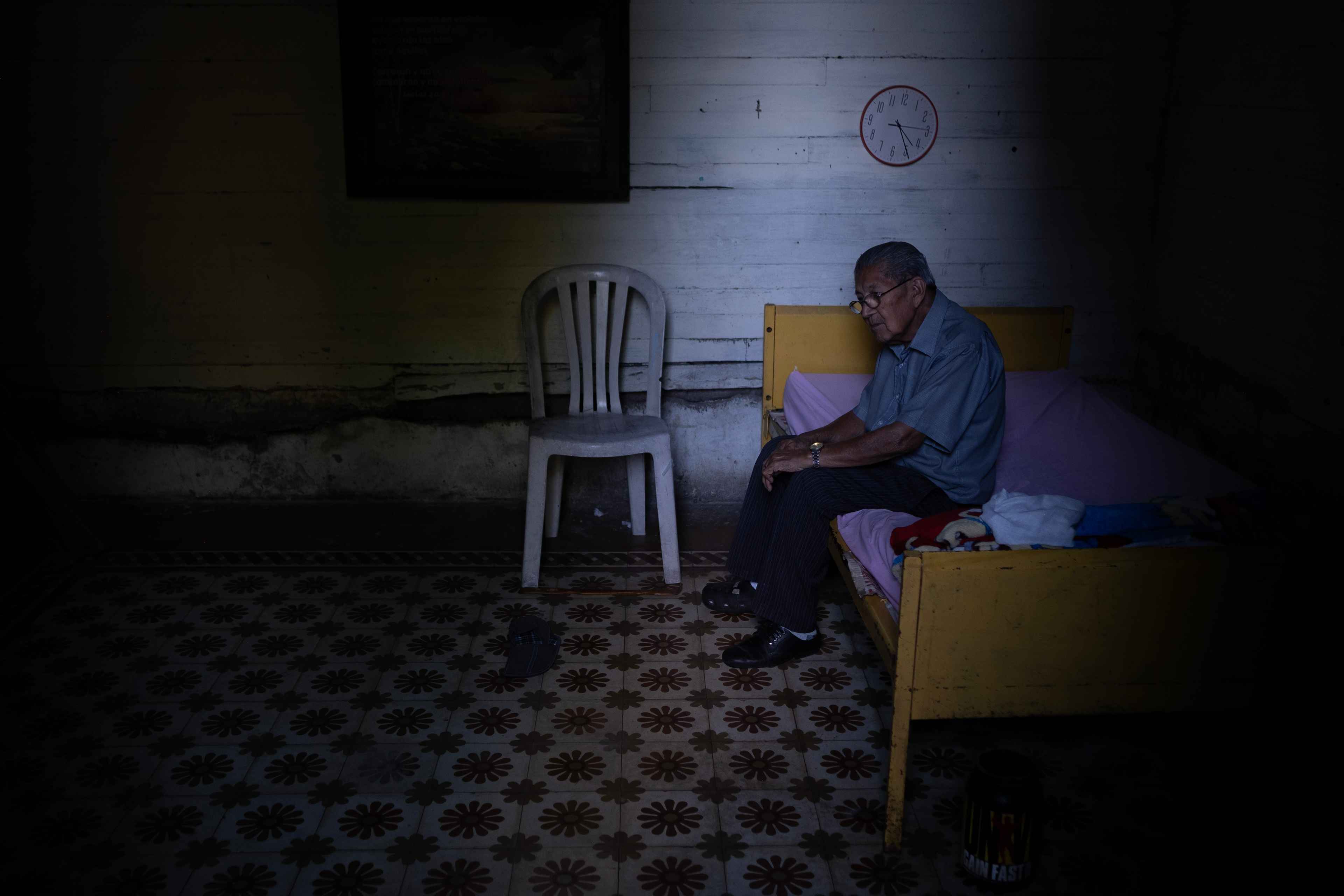 Han pasado 4 años desde que Fabián González resistía como el último peluquero que trabajaba en plena pandemia de covid-19 en el Centro Histórico. Fabián, que ahora tiene 86 años, ha trabajado permanentemente y vivido intermitentemente en El Centro desde 1985. Ahora vive en la habitación que era de su hijo, quien a causa de la depresión se suicidó. El mesón, del que Fabián es el único inquilino, está a una cuadra de la Plaza Libertad. Paga $65 por el cuarto que durante la pandemia costaba $45. "Todas las cosas han subido de precio, El Centro ahora es una belleza que nosotros no podemos pagar", dice sentado en la oscura habitación cercana a las luces y bullicios de la villa navideña de la Plaza Libertad. Foto de El Faro: Carlos Barrera