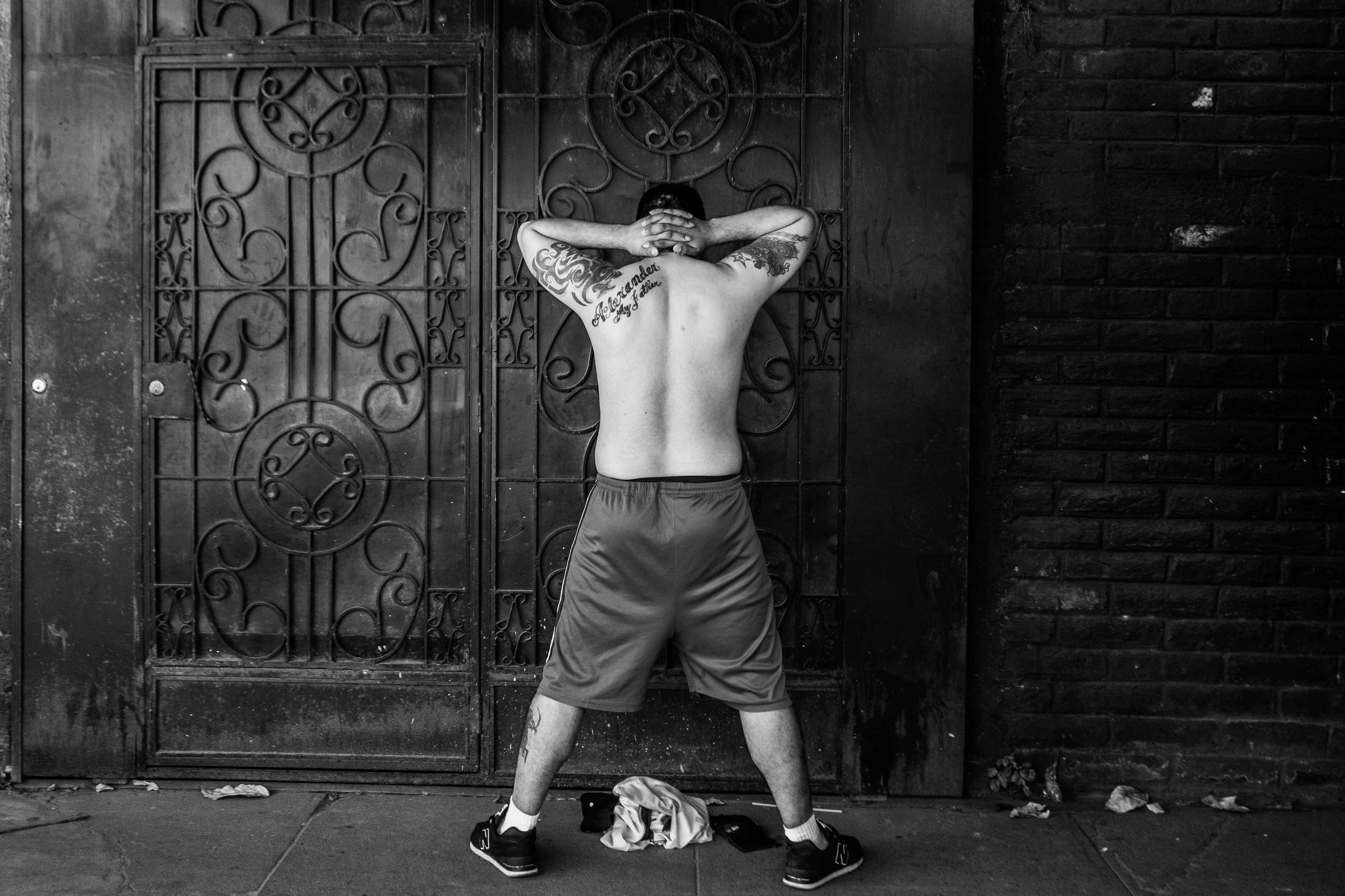 Un hombre con tatuajes no alusivos a pandillas espera ser interrogado por soldados el 3 de diciembre de 2022 durante el cerco militar en Las Margaritas, Soyapango. Según organizaciones de derechos humanos, tener tatuajes fue la razón por la que muchos fueron arrestados durante el régimen de excepción en el país.