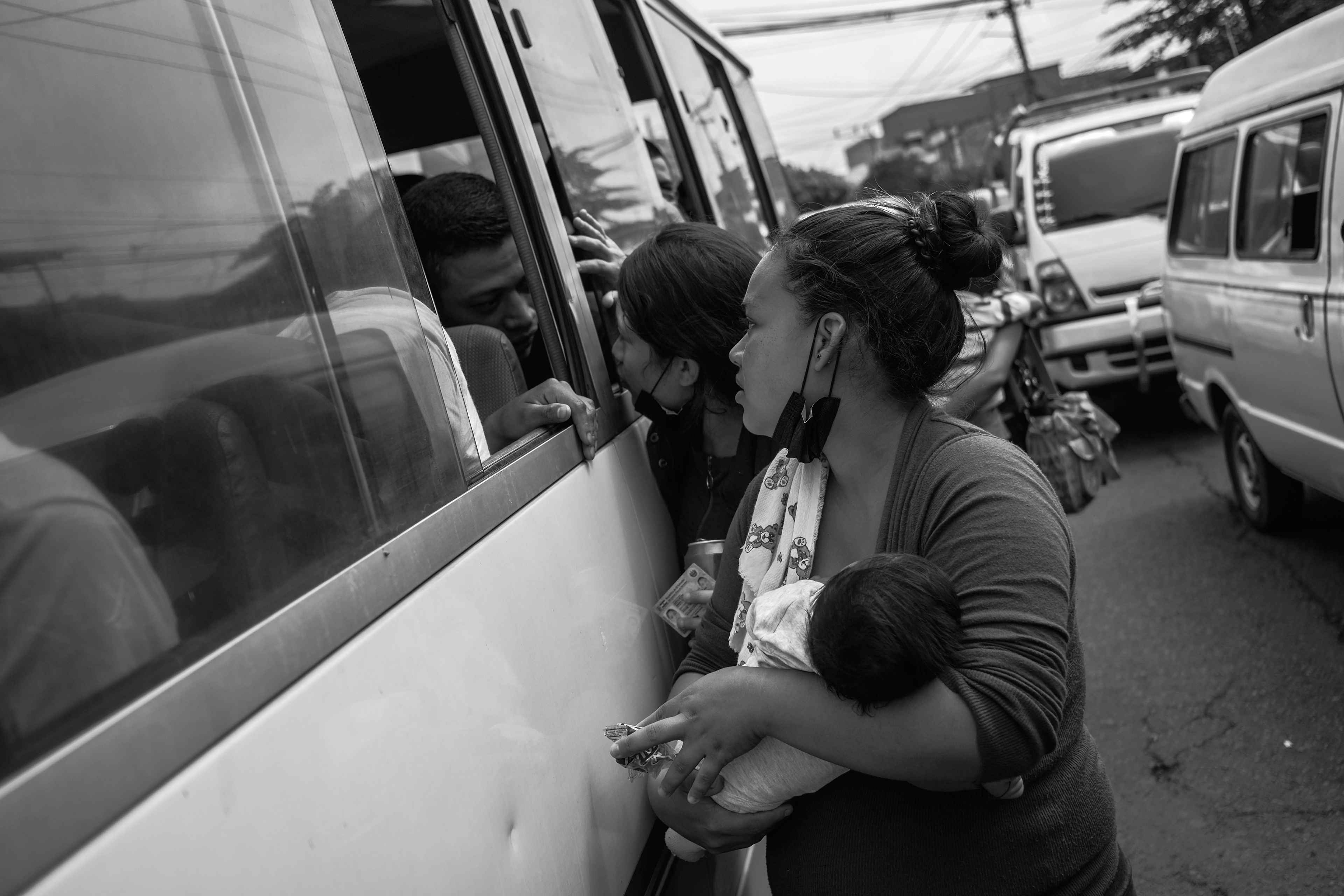 Una mujer carga a su bebé e intenta hablar con su marido capturado durante los primeros días del régimen de excepción en 2022. Miles de familias han sido separadas debido a las capturas masivas durante los tres años del régimen.