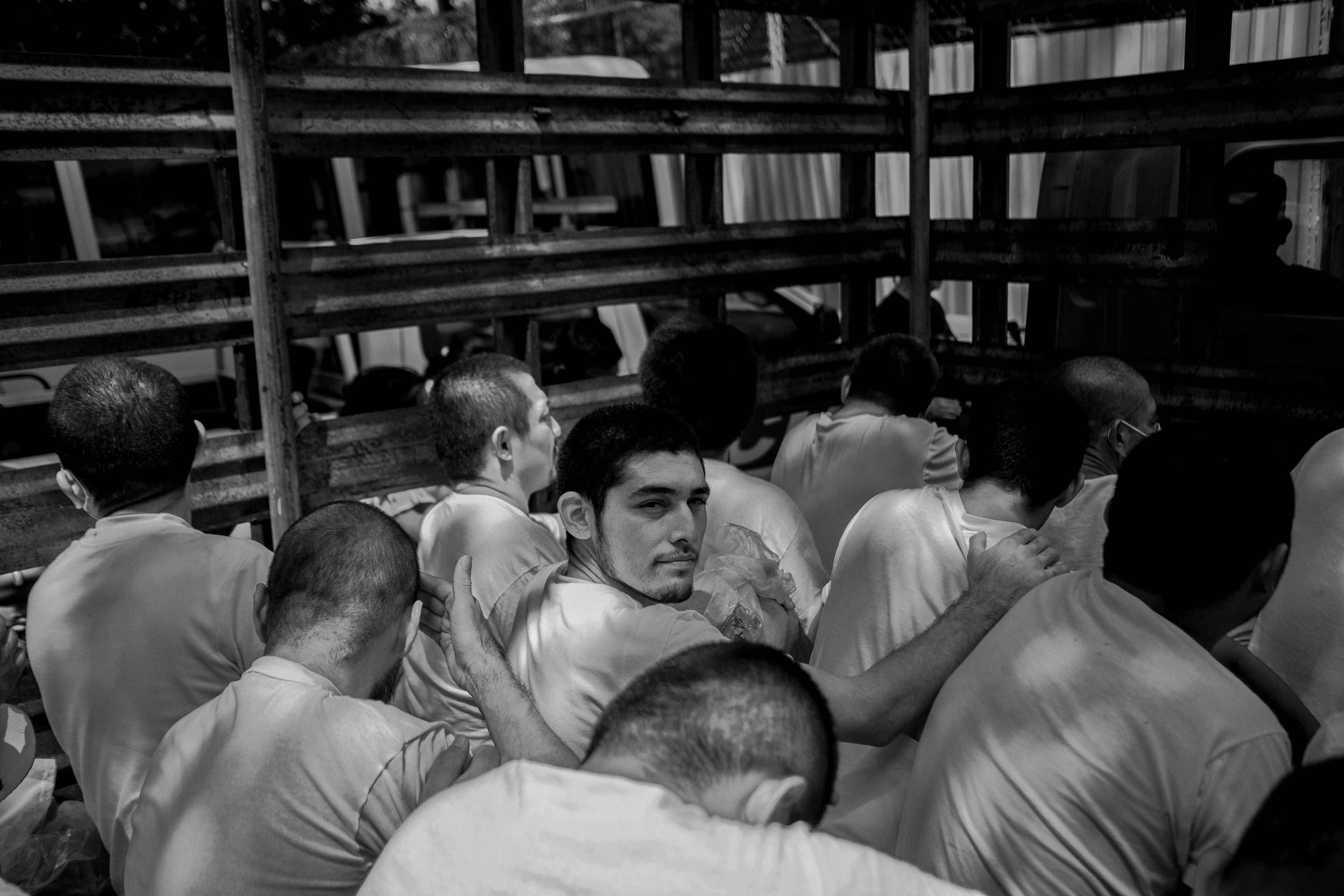 Personas arrestadas en septiembre de 2022 durante el régimen de excepción, momentos antes de ingresar a la cárcel de Ilopango, San Salvador. En la mayoría de los casos, las personas llevan casi tres años en prisión sin el debido proceso. Los juicios se realizaban en grupos masivos y miles de casos no están individualizados.