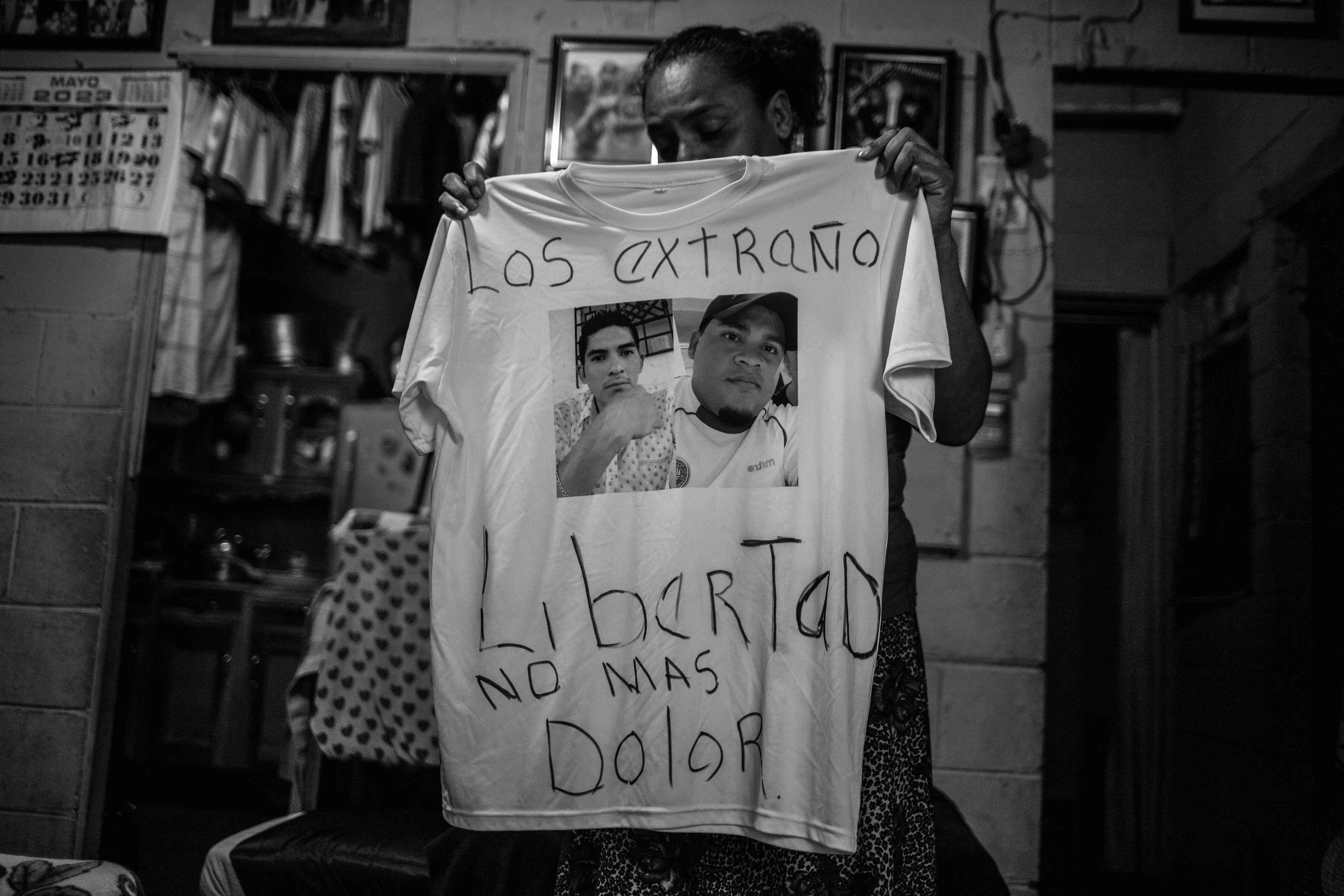 Cecilia Abrego sostiene una camiseta con la foto de sus hijos capturados durante el régimen. Cecilia padece cáncer y debe conseguir dinero para su tratamiento y enviar paquetes a sus hijos detenidos. Además, tras las capturas, tuvo que hacerse cargo de sus nietos.