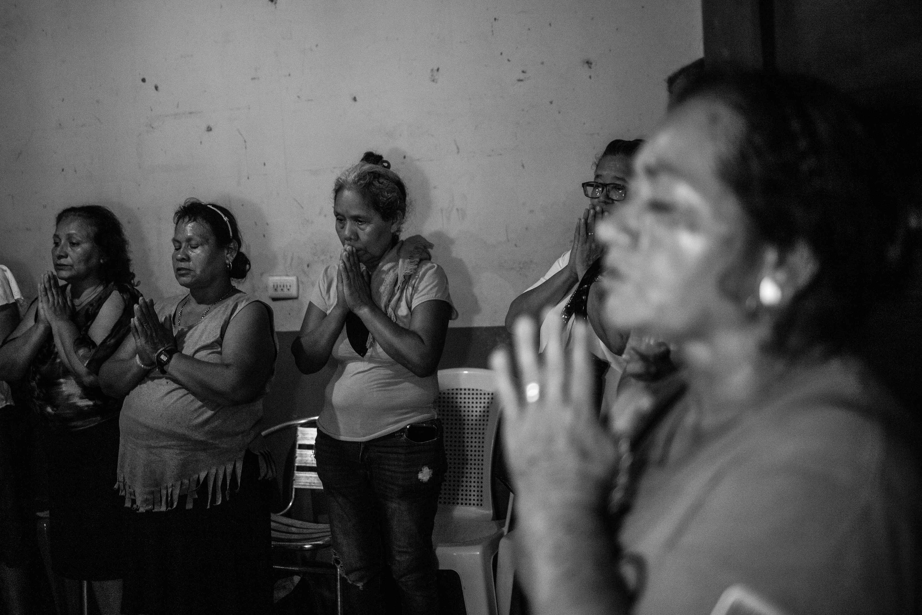 Familiares de Juan Saúl, un trabajador de 32 años, rezan durante una conmemoración tras su funeral. Juan falleció tras sufrir cáncer de oído y no recibir el tratamiento adecuado en prisión. Juan Saúl no tenía antecedentes penales, pero la policía lo capturó.
