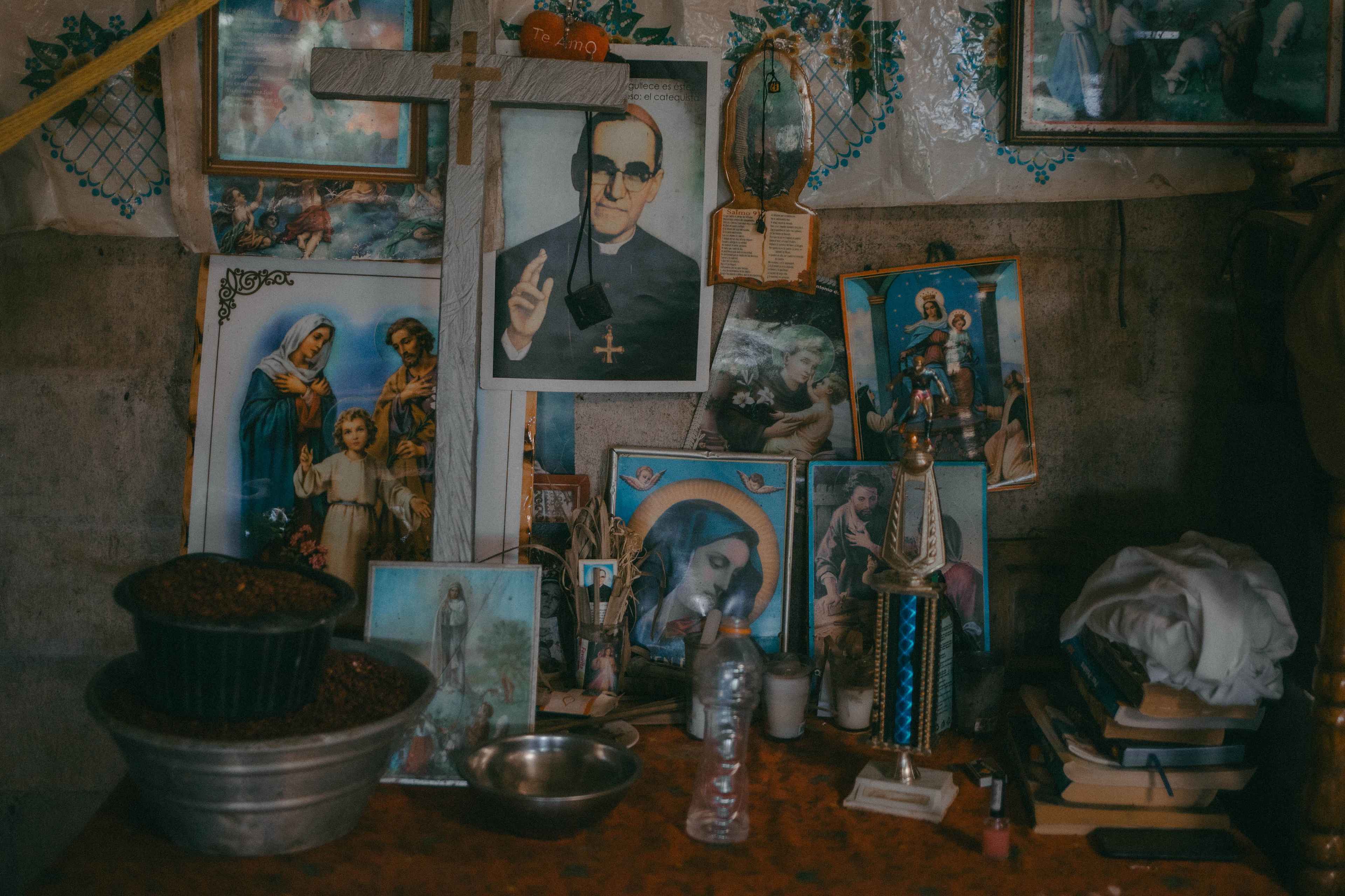 Given the state’s inaction to provide basic services, communities of Berlín embrace their faith to endure the precariousness. In the house of Isidro Benítez, every time they clean some beans or corn, they place containers of grain on an altar with Monsignor Óscar Romero in the center. They ask that at least they not lack rainwater, and that they be able to harvest.